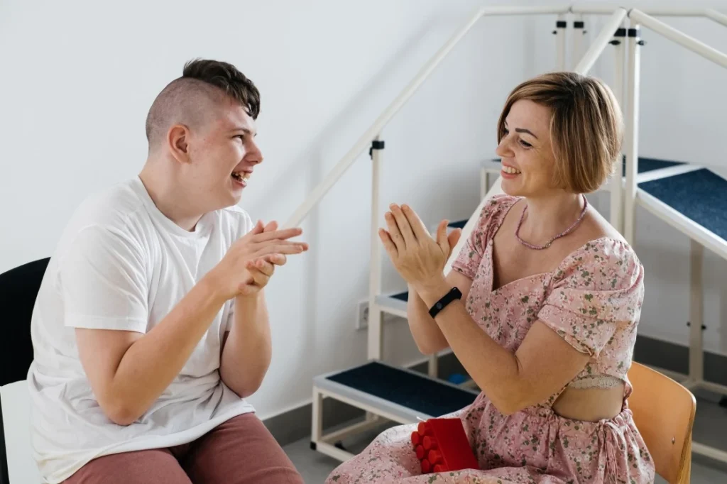 Disabled man smiling happily with support worker